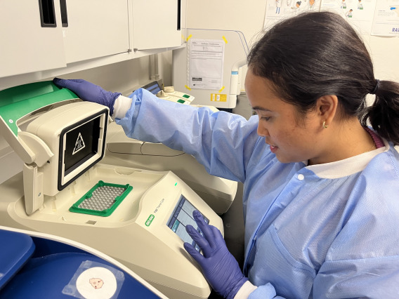 Technician opening PCR machine
