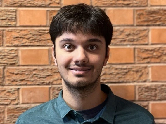 Image of Noah Sharma in front of a brick wall