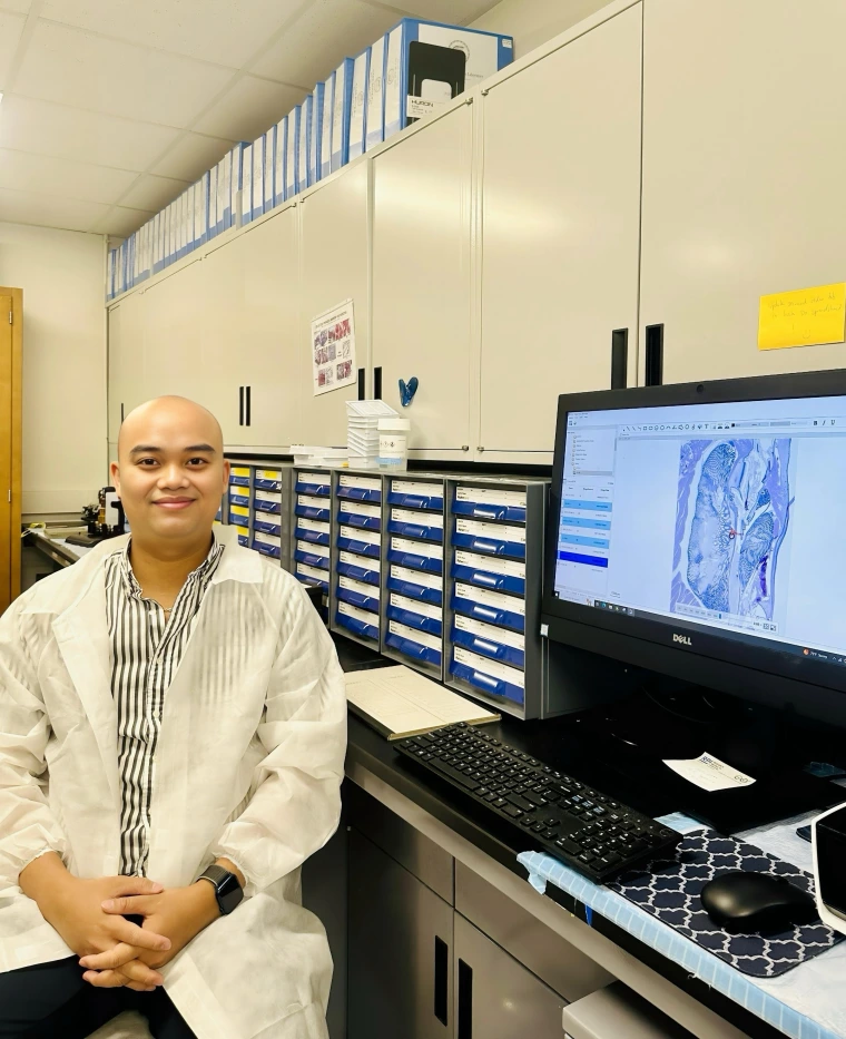 Henry next to a computer with a histology image