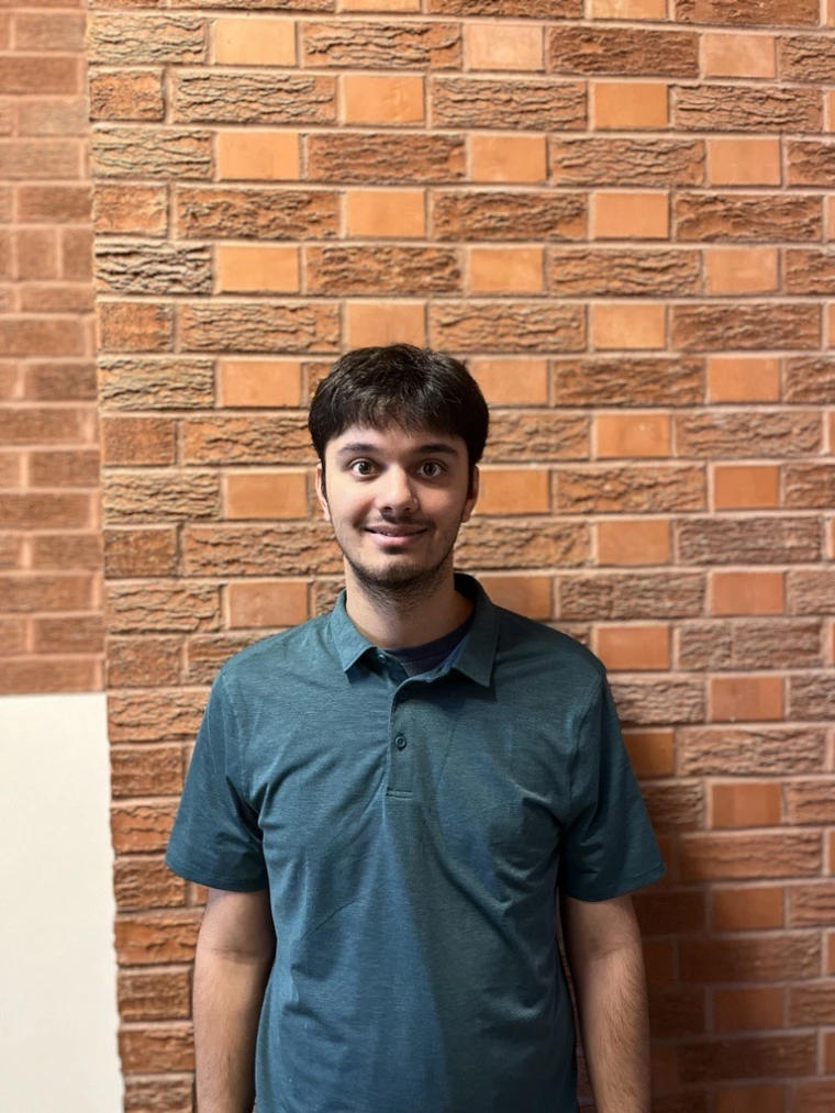 Image of Noah Sharma in front of a brick wall